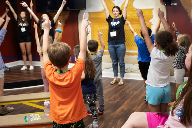 Children learning hand motions to a song.