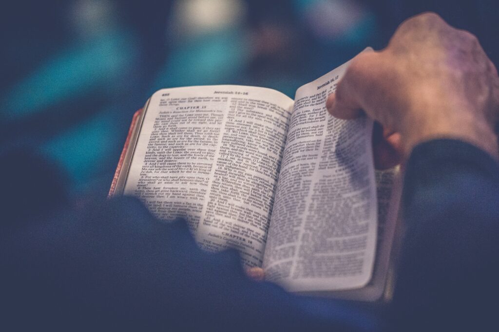 Hands shown flipping the pages of a Bible.